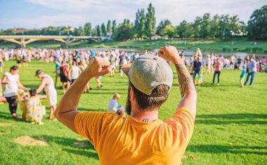 Açık hava konseri. Şehir günü. Müzik festivali. Eğlence konsepti. Yaz festivalini ziyaret et. Adam bayramı ya da festivali kutluyor. Yaz festivali. Kalabalığın önünde sakallı hippi adam. Kitap bileti.