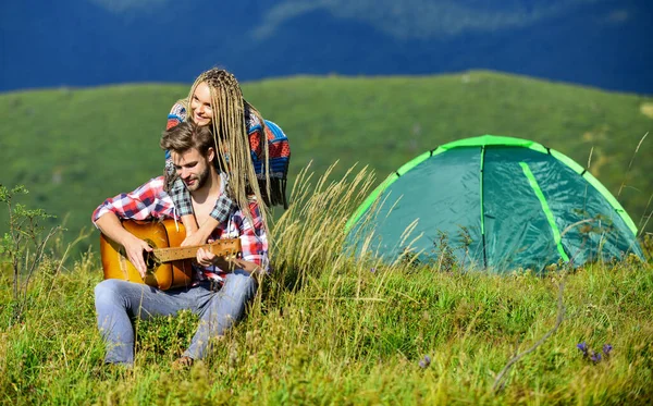 Fiind îndrăgostit. camping occidental. Drumeţii. Prieteni fericiti cu chitara. muzică country. întâlnire romantică. prietenie. Cântece de foc. Bărbații cântă la chitară pentru fată. cuplu în dragoste petrece timp liber împreună — Fotografie, imagine de stoc