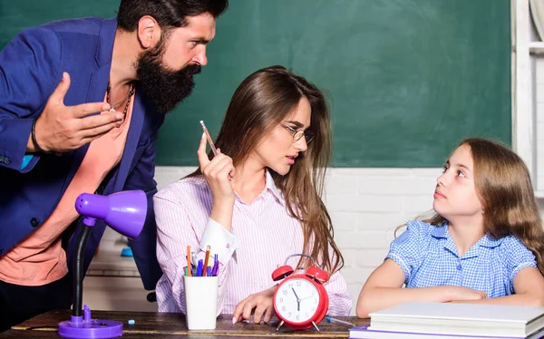 Grootste nadeel overbeschermende opvoeding stijl slecht voorbereide kinderen. Overbeschermende familie. Overbeschermende ouderstijl. Een klein meisje dat huiswerk maakt. Papa 's moeder geeft les. Intelligente familie — Stockfoto