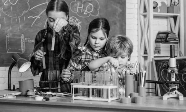 Η κόρη κοιτάζει μέσα από μικροσκόπιο στο δημοτικό σχολείο. πειραματίζονται με χημικές ουσίες ή μικροσκόπιο στο εργαστήριο. Χαρούμενα παιδιά δασκάλα. Πίσω στο σχολείο. Εργαστηριακός εξοπλισμός σχολής βιολογίας — Φωτογραφία Αρχείου