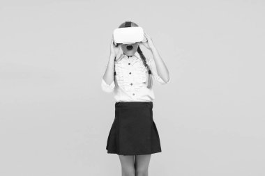 Yeni gerçekliğin tadını çıkar. Mutlu çocuk modern teknoloji kullanıyor. Gelecekteki eğitim. Okula dönüyorum. Dijital gelecek ve yenilik. Sanal gerçeklik. VR kulaklıklı küçük kız. Küçük çocuk kablosuz VR gözlük takıyor