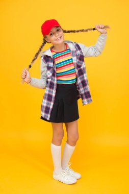 Saç modelinin bütün gün sürmesini sağlamak. Saçları örülmüş, sarı bir geçmişi olan mutlu çocuk. Uzun saçlı, küçük tatlı kız gülüşü. At kuyruklu saç stili modası.