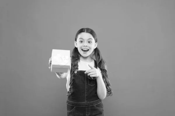 La entrega más temprana con calidad. Adorable niña sosteniendo la caja presente sobre fondo naranja. Tienda de regalos con servicio de entrega. Entrega de regalo rápido es seguro que por favor. Entrega presente perfecta —  Fotos de Stock