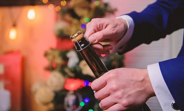 Celebremos. Abrir el champán y celebrar la fiesta. Celebra el año nuevo con bebida de champán. Concepto de brindis y salud. Manos masculinas abriendo botella de champán en decoraciones de Navidad fondo —  Fotos de Stock