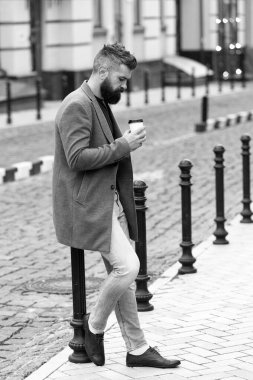 Yürümek ve taze sıcak kahve keyfini çıkarın. Biri sokakta bekleniyor. Adam hipster içki kahve kağıt bardak sakallı. İyi bakımlı işadamı kahve arası açık havada kentsel arka plan tadını çıkarın. Kahve zaman zevk