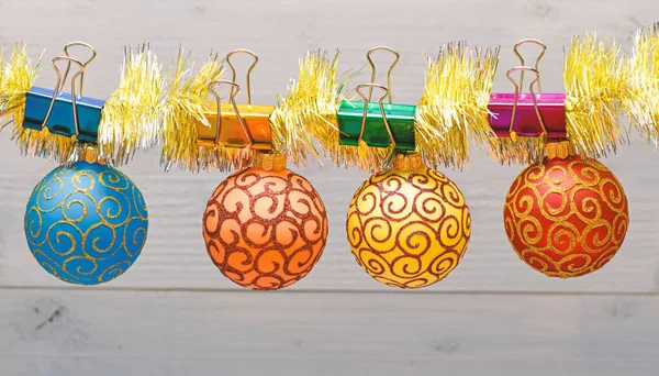 在木制背景上固定的圣诞装饰品的丁底花。圣诞饰品的概念。闪闪发光的金丝上挂着有装饰品的球。选择五颜六色的装饰为圣诞树 — 图库照片