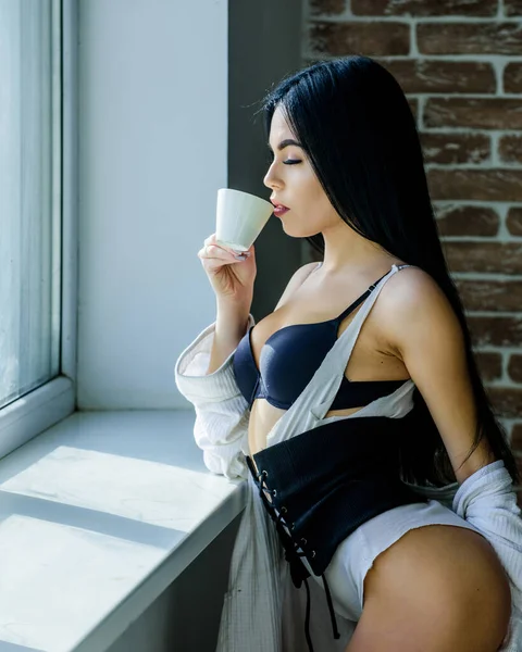 Hora perfeita do café. Mas primeiro café. Tranquilidade e paz. Um gole de cappuccino cremoso. Ritual da manhã. Menina curvas perfeitas corpo beber café perto do peitoril da janela. Mulher de cueca relaxante em casa — Fotografia de Stock