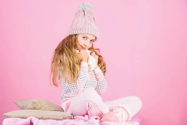 Дівчинка носить в'язаний теплий капелюх, розслабляючий рожевий фон. Концепція теплого одягу зимової моди. Теплі аксесуари, які збережуть вам затишну зиму. Дитячий довге волосся теплий вовняний капелюх насолоджуйтесь теплом і м'якістю — стокове фото