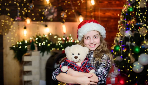 Dreams come true. Kid near christmas tree hold teddy bear soft toy. Childhood memories. Girl satisfied christmas gift. Christmas gift she dreamed about. Best gift ever. Happy new year concept