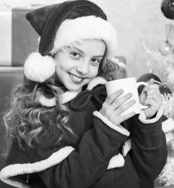 Перфектный способ согреть вас праздничным сезоном. Девочка маленький милый ребенок держать кружку с горячим напитком во время празднования Рождества. Горячий какао на Рождество. Любимый напиток какао. Малыш Санта шляпа насладиться какао напитком — стоковое фото