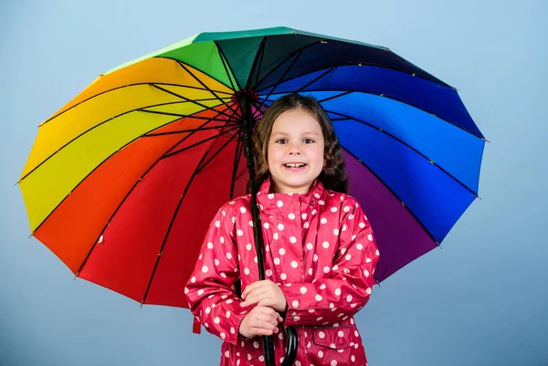 Saison d'automne. Enfant fille heureux tenir parapluie arc-en-ciel coloré. Météo pluvieuse avec des vêtements appropriés. Amusant jour de pluie. Bonne promenade sous le parapluie. Il y a toujours un arc-en-ciel après la pluie. Profitez concept de pluie — Photo