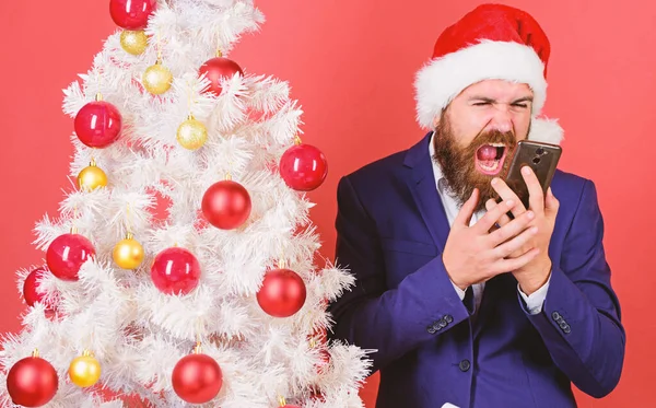 Guy annoyed by quality of mobile connection holiday day. Mobile tariff roaming. Man bearded face wear suit and santa hat hold phone. Congratulate relatives abroad mobile call. Cell network overload