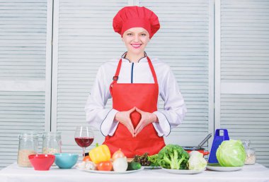 Aşçılık dersi veren harika bir aşçı. Aşçılık yeteneğini geliştir. Evde denemek için en iyi yemek tarifleri. Yemek programıma hoş geldiniz. Güzel bir kadın şapka ve önlük giyer. Profesyonel şef için üniforma.