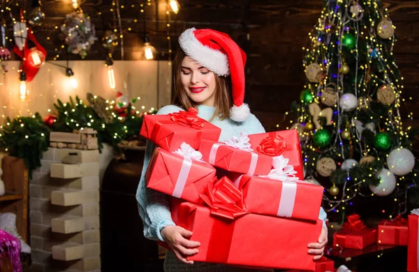 Portare la magia in qualcuno elses vita. Lady Babbo Natale festeggiare il Natale a casa. Ragazza trucco elegante labbra rosse tenere molti regali di Natale. Accogliente atmosfera natalizia. Cappello donna Santa Claus alla vigilia di Natale — Foto Stock