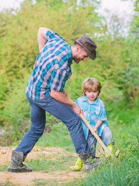 Hazineleri bulun. Küçük çocuk ve baba kürek hazineleri arıyor. Mutlu çocukluk. Hazineler için Macera avcılık. Bahçede çalışan küçük bir yardımcı. Doğada sevimli çocuk kürek ile eğlenmek