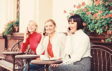 Dijital cihazları kullanma. Grup kadın kafe Teras. Mobil bağımlısı. Mobil konuşma. Cep telefonları olan kızlar. Arkadaşlar kahve dükkanında oturup konuşma keyfini çıkarın. Konuşmaya takıntılı. Dostluk toplantısı