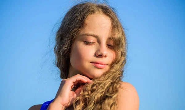 A sentir-se brincalhão. moda infantil. criança bonita ao ar livre. beleza natural. menina pequena cabelo longo culry. infância feliz. pele perfeita e saudável. A juventude é brilhante. férias de verão. desfrutar de bom tempo — Fotografia de Stock