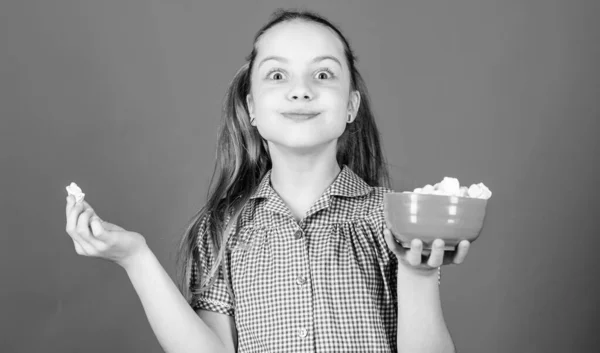 Calorias e dieta. Menina sorridente rosto segurar tigela doce marshmallows na mão fundo azul. Miúda com cabelos longos gosta de doces e guloseimas. Quem se importa com a dieta? Doce e suave. Conceito de dente doce — Fotografia de Stock