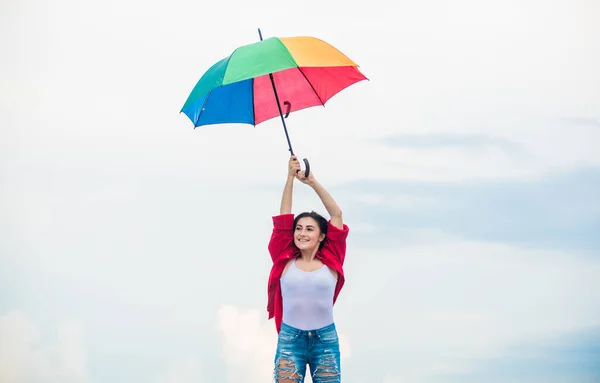 Parachute concept. Open minded person. Girl feeling good sky background. Good weather. Welcoming fall. Pretty woman with colorful umbrella. Rainbow umbrella. Rainy weather. Good mood. Good vibes