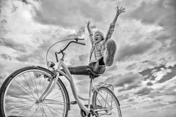 Жінка почувається щасливою, насолоджуючись їздою на велосипеді. Дівчина катається на велосипедному фоні неба. Як велосипед змінює ваше життя і робить вас щасливими. Причини їздити на велосипеді. Психічне здоров'я переваги. Педаль до щастя — стокове фото
