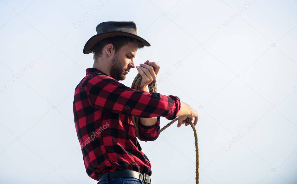 old west. man checkered shirt on ranch. wild west rodeo. Thoughtful man in hat. cowboy with lasso rope. Western. Vintage style man. Wild West retro cowboy. western cowboy portrait