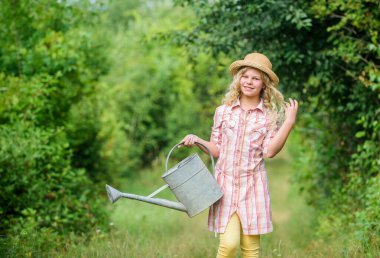 İşim benim tutkum. Spring Country Side Köyü. Yaz sezonu. Sulama kutusu olan küçük bir kız. Toprak günü. Çevre ekolojisi. Doğa koruması. dişi çiftçi bakım bitkileri. Çiftçilik ve tarım