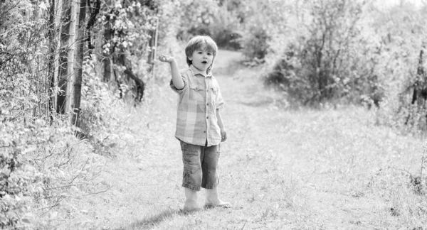 happy child farmer in rubber boots, spring. human and nature. earth day. Eco life. summer activity. small kid gardener walking in forest. farming and agriculture. Enjoying spring day