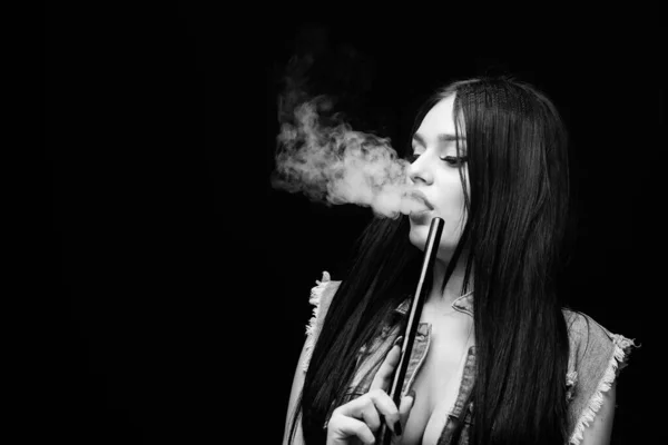 Rest and relax. Hookah bar. Electronic cigarette. Fashion girl vaping. White cloud of smoke. Vaping is sexy. Nicotine addiction. Glamorous brunette smoking vaping device black background. Girl vaping