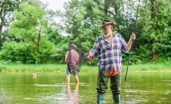 Fishing therapy. grandfather fishing. male friendship. family bonding. summer weekend. fishermen with fishing rods, selective focus. retired mature man fisher. hobby and sport activity — Stock Photo, Image