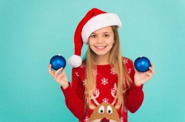 Biraz daha dekorasyon ekle. Çocuğu dekorasyona dahil etmek. Noel ağacı süslemek. Gülen surat, topları tutarken mavi arka planı süsler. Bırak çocuk Noel ağacını süslesin. Favori parça dekorasyonu