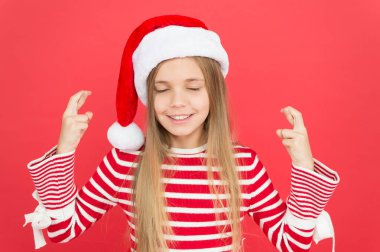 En iyisi için umut. Noel partisi. Neşeli kız Noel arifesinde eğleniyor. En iyi dileklerimle. Çocuk Noel Baba kostümü mucizeye inanır. Kırmızı arka plandaki küçük kız. Mutlu Noeller ve mutlu yıllar.