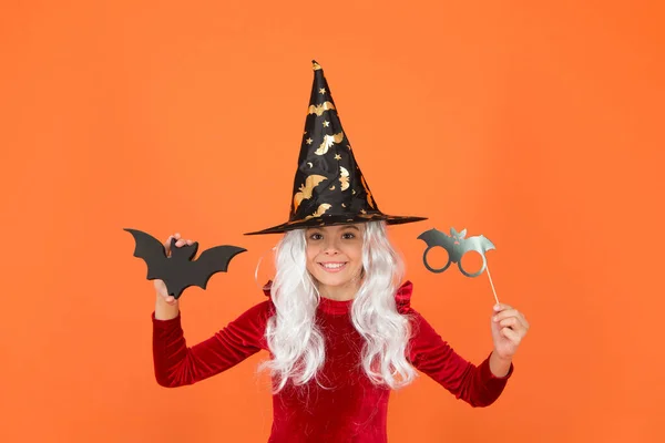 The scariest party tonight. Party girl with Halloween props orange background. Small child wear wicked witch party costume. Halloween kid with party look. Scary holidays. Holiday celebration — Stock Photo, Image
