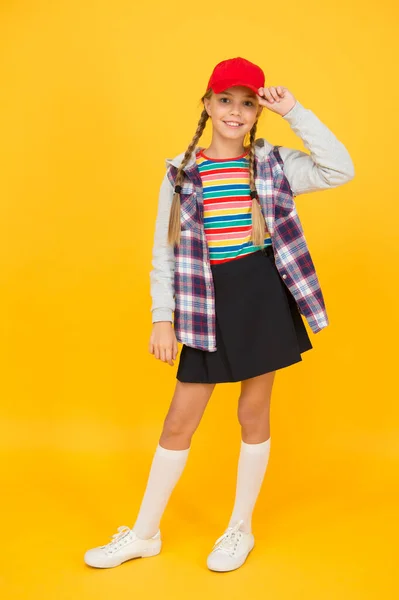 Tomboy concept. Tiener leeftijd. Meisje schattig stijlvolle outfit tiener. Comfortabele outfit. Moderne kleding. Een opstandige tiener. Straatstijl. Cool schoolmeisje. Veel plezier charismatisch meisje op gele achtergrond — Stockfoto