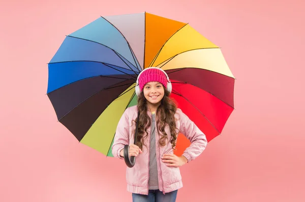 La lluvia es mi música favorita. Niño pequeño feliz con paraguas de color arco iris para el paseo de otoño. Niño sonriendo con paraguas para el clima lluvioso de otoño. Accesorio de otoño de moda. Temporada de otoño — Foto de Stock