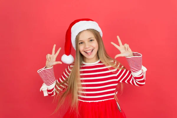Joyeux gamin. Le costume de père Noël croit au miracle. Petite fille sur fond rouge. Joyeux Noël et bonne année. Fête de Noël. Fille joyeuse s'amuser la veille de Noël. Meilleurs voeux — Photo