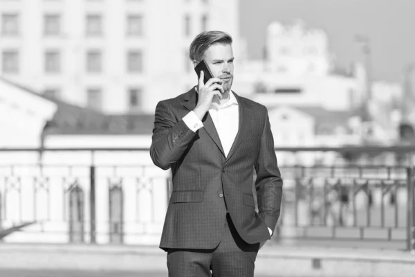 自信のあるビジネスマンが電話で話してる。ビジネスを展開している。携帯電話を持ってるビジネスマンだ。無線接続だ。ビジネスオンライン。億万長者だ。ファッションスーツのハンサムな男。現代の生活 — ストック写真