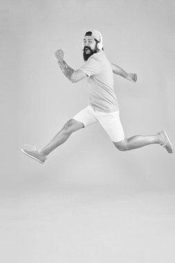 Aceleci hareket. Hipster dans atlama kulaklık gadget. İlham verici bir şarkı. Müzik kütüphanesi. Ritim enerjisi. Sakallı adam müzikten hoşlanır. Müzik hayranı. Adam hareket halinde müzik kablosuz kulaklık dinlemek