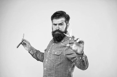 Retro ve eski moda. Sakallı adam retro jilet ve makas tutuyor. İş yerinde retro araçları ile profesyonel berber. Retro berber klasik kesim, vintage filtre uzmanlaşmış