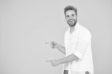 Şuraya bak. Adam fotokopi alanını işaret ediyor. Şuna bir bak. Sarı arka planda, kaslı, yakışıklı, gülümseyen, traşsız, parmağıyla işaret eden adam. Reklam konsepti. Yaz reklamı. Reklam ajansı