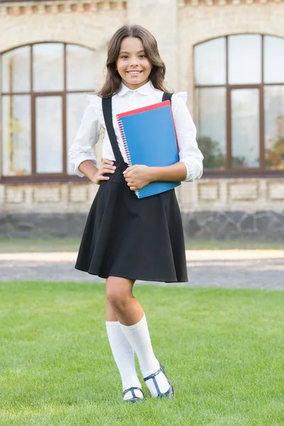 Il ne faut pas grand-chose pour rendre le rat de bibliothèque heureux. Joyeux petit enfant tenir livres de bibliothèque en plein air. Petite fille retournant à l'école. Un rat de bibliothèque de mode. Elle lit bien les vers de bibliothèque. Concept de ver de bibliothèque — Photo