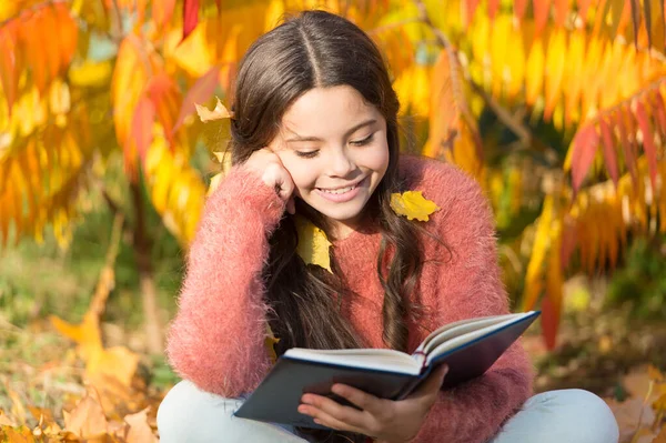 Su pasatiempo es leer. Lindo libro de lectura de niños pequeños en el día de otoño. Adorable niña disfrutan de la literatura inglesa. Literatura infantil. Educación literaria. Infancia en la literatura —  Fotos de Stock