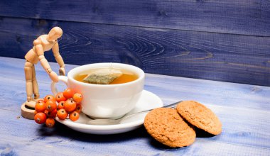 Seramik fincan sıcak demlenmiş çay içeceği. Aromatik rowanberry içeceği için. Sağlık hizmetleri kocakarı ilaçları. Mavi arka planda bir fincan çay yakın plan. Lezzetli gurme tadı. Kafe menüsü. Çilek çayı.