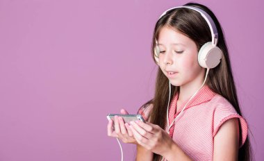 Kişisel eğitim. Mp3 çalar. Kulaklık takan küçük bir kız öğrenci. İnternette çocuk eğitimi. Kitapla öğreniyorum. Evde eğitim. Kız müzik dinler. Ses kitabı. Okula dönüyorum. Çok çalışıyorum. Boşluğu kopyala