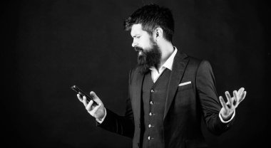 Online hizmet ve uygulama. Modern teknolojiler. İşadamı bakımlı adam akıllı telefon tutun. Adam resmi takım akıllı telefon sosyal ağlar kullanın. Adam sörf internet akıllı telefon siyah arka plan