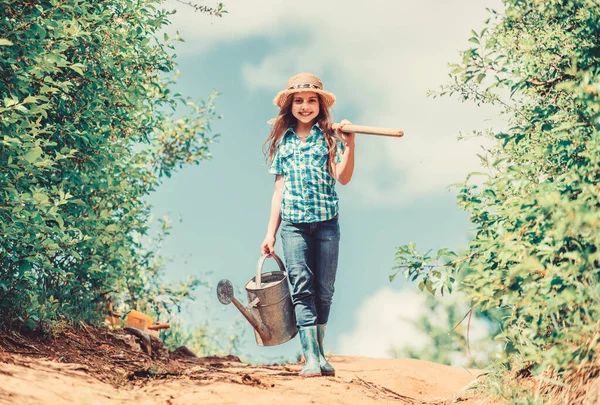 Spring gardening checklist. Little helper. Watering tools that will solve dry yard problems. Removable rose allows moderate flow. Gardening tips. Spring gardening. Girl child hold shovel watering can — Stock Photo, Image