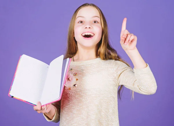 Got great plans for education. Cute small child keeping finger raised and open education book. Adorable little girl getting formal education in primary school. Education is compulsory, copy space