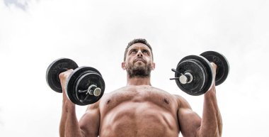 Kaslı adam dumbbell ile egzersiz. Güçlü gövdesi olan Sportsman. Spor ekipmanları. Fitness ve vücut geliştirme sporu. Spor yaşam tarzı. Başarı tercihtir. Kazanmak alışkanlıktır. Dumbbell egzersiz spor salonu