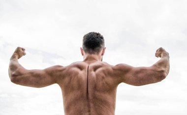 Ben her şeyi yapabilirim. Kaslı vücutlu bir adam. Adam ya da sporcu yumruklarla kollarını esnetiyor, arka görüşe. kaslı geri adam beyaz izole. Başarı kavramı. Güçlü kaslar ve güç