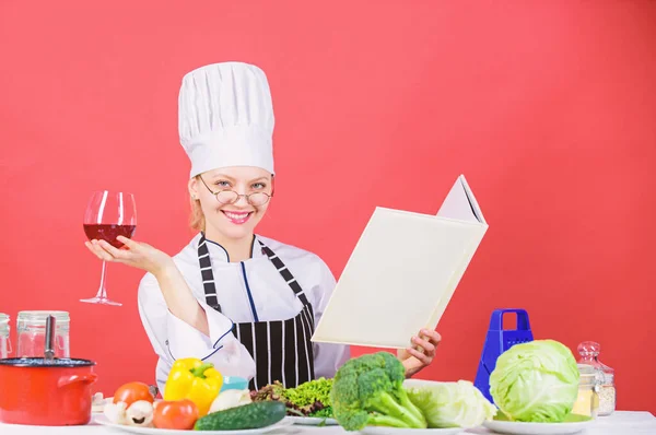 Professional level. Woman hat and apron study culinary arts. Culinary expert. Chef cooking healthy food. Girl read book best culinary recipes. Culinary school concept. Book by famous chef copy space