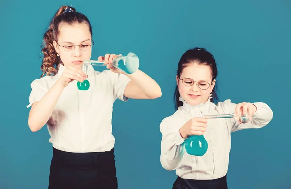 school kid scientist studying science. little smart girls with testing flask. children study chemistry lab. biology education. back to school. Checking the results. what the result will be